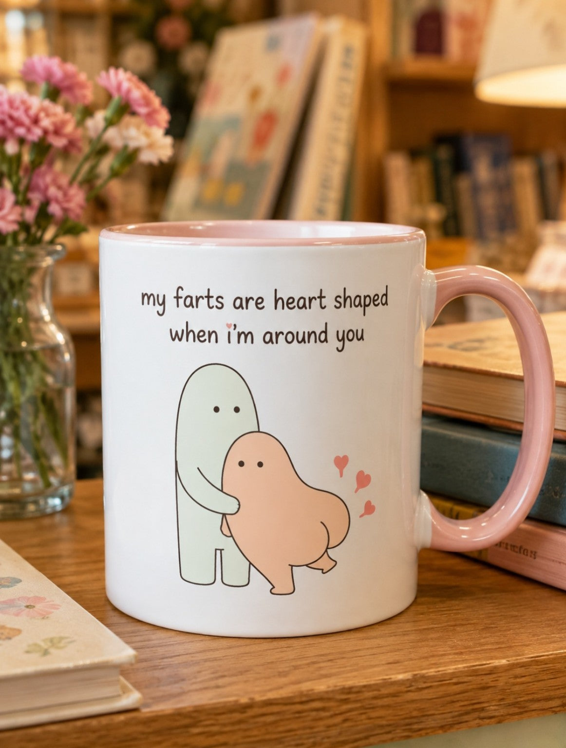 White mug with a pink handle showing a cute couple illustration and the text My farts are heart shaped when I’m around you